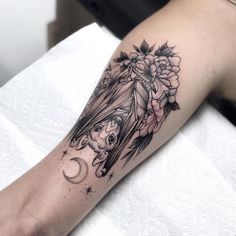 a woman's arm with a bat and flowers on it