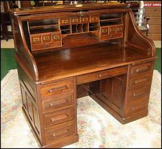 an antique wooden desk with drawers on display in a storeroom or home office area