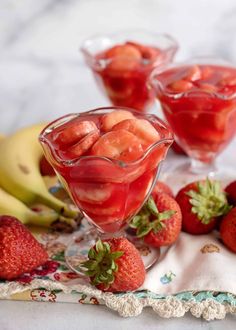 some strawberries are in a glass bowl on a table