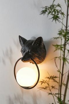 a cat head mounted to the side of a wall with a ring around it's neck