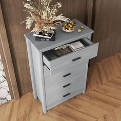 a small grey cabinet with drawers and a bowl of fruit on top