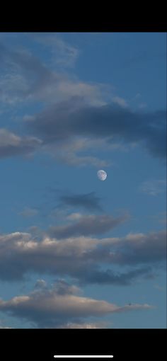 the moon is seen through some clouds on a clear day in this photo, it looks like there is no image to describe