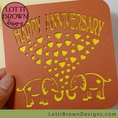 someone is holding up a card that says happy anniversary with elephants and hearts on it