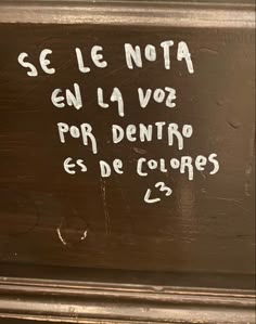 a sign that is written on the side of a building with writing in spanish and english