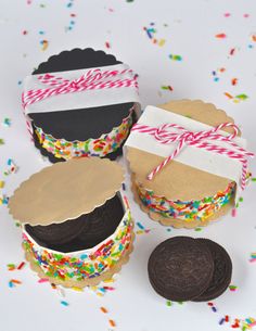 some cookies are wrapped in paper and sitting next to each other with sprinkles on them