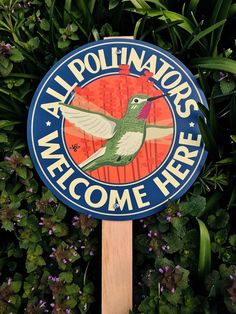 a blue and white sign that says all pollinotors welcome here with a hummingbird on it