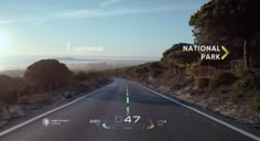 an image of a car driving down the road in front of a sign that says national park