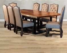 a dining table with six chairs and a bench in front of it on a hard wood floor