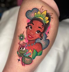 a woman's leg with an image of a princess and frog tattoo on it