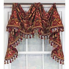 a window curtain with tassels hanging from it's side, in front of a window