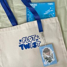 a tote bag with a photo hanging from it's front and the words plot twist on it