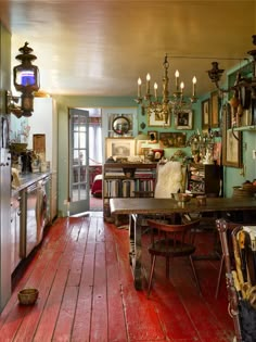 an old fashioned dining room with red wood floors