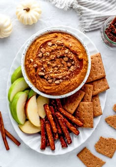 pumpkin pie dessert hummus on a plate with crackers, apples and cinnamon sticks