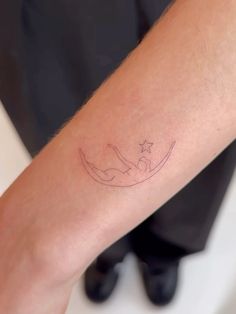 a person with a star and crescent tattoo on their left arm, sitting in a chair