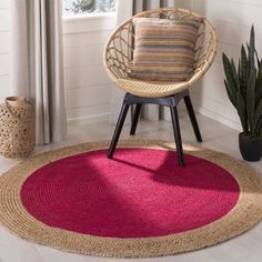 a living room with a chair, rug and potted plant