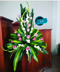 a bouquet of pink and white flowers sitting on top of a church pew