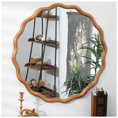 a round mirror sitting on top of a wooden shelf