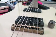 an electric guitar with some knobs on it's head and strings in the foreground