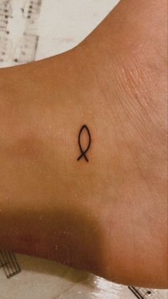 a small tattoo on the ankle of a woman's foot with an egyptian symbol