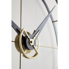 a close up of a clock face on a white wall with blue hands and gold accents