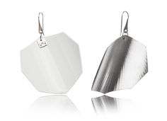 two silver earrings are shown on a white surface and one is in the shape of a hexagon