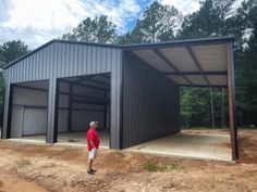 a man standing in front of a building with two garages on the side of it