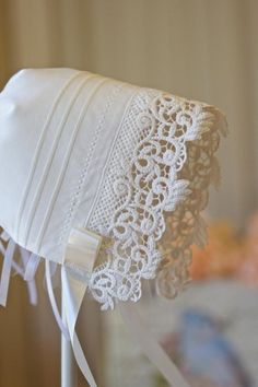 a white hat with lace on it sitting on top of a table