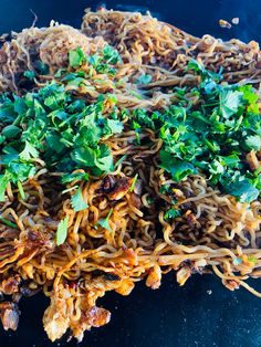 noodles with greens and meat on a blue plate