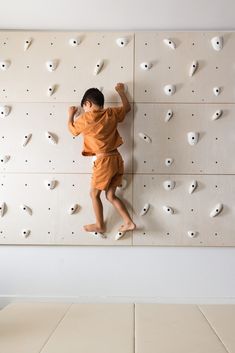 a young boy climbing up the side of a rock wall