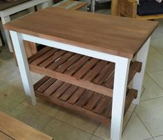 a kitchen island made out of wood and white paint with two shelves on each side