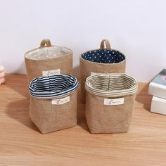 three storage baskets sitting on top of a wooden table next to a small box with polka dots