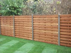 a wooden fence with grass in the yard