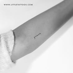 a woman's arm with a small tattoo on it that says peace in cursive writing