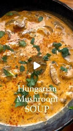 a pan filled with mushroom soup on top of a wooden table