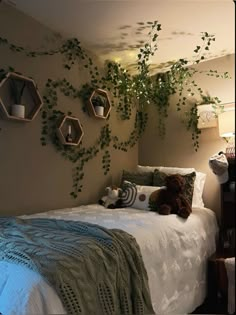 there is a bed with plants growing on the wall above it and a teddy bear