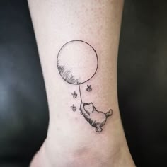 a cat flying with a balloon tattoo on the ankle