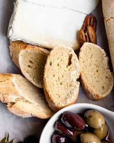 bread, olives and nuts are on the table