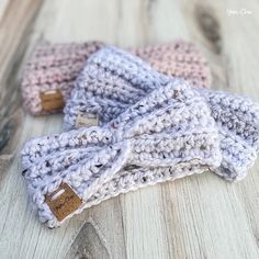 three crocheted headbands sitting on top of a wooden table