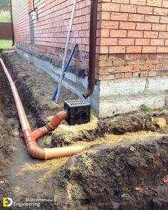 the pipe is connected to the brick wall and has been dug into the ground for drainage