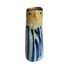 a blue and white vase with a face painted on the side, sitting in front of a white background