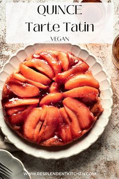 a tarte tatin on a white plate next to silverware and utensils