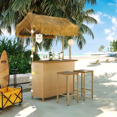 an outdoor bar with two stools and a surfboard in front of palm trees