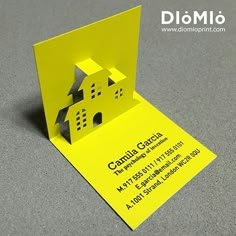 a yellow business card with a house cut out of it