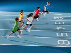 four children running on a blue tennis court