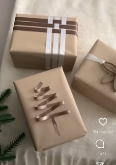 three wrapped presents sitting on top of a bed