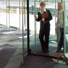 a woman standing in front of a glass door