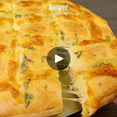 a cheese and spinach quiche being cut into pieces with a knife on the side