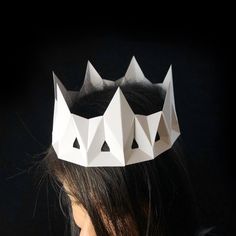 a woman wearing a paper crown with three crowns on her head and one has long black hair