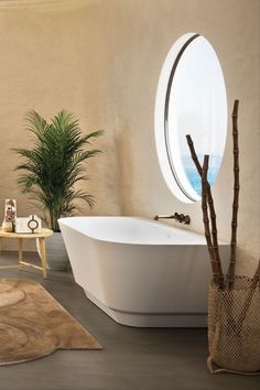 a bathroom with a round window and a white bathtub in the middle of it