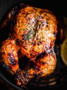 grilled chicken in a pan with lemon wedges